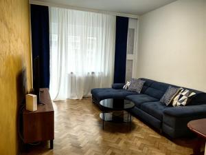 a living room with a blue couch and a table at Apartman Cetkovic in Belgrade