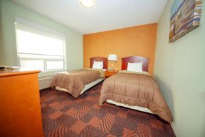 Postel nebo postele na pokoji v ubytování Service Plus Inns and Suites Calgary