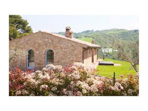 una piccola casa in pietra con un cortile fiorito di Villa Marta a Volterra