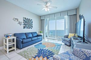 a living room with a blue couch and a tv at Lighthouse 1610 in Gulf Shores