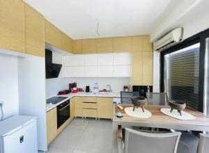 a kitchen with white cabinets and a wooden table at HuzUrla in Urla