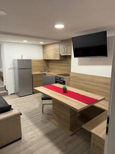a kitchen with a table and a television on the wall at Kamrca na Kopah in Šmartno pri Slovenj Gradcu
