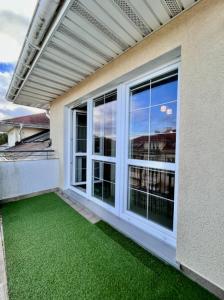 a balcony with green grass next to a building at Apartament Spacerowa in Grzybowo