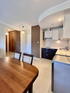 a large kitchen with a wooden table and chairs at Apartament Spacerowa in Grzybowo