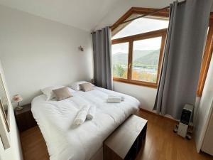 a bedroom with a large white bed with a window at Alsace Mountain House in Munster
