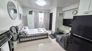 a living room with a couch and a tv at JTropics Plumera Mactan Near Airports, Malls and Beaches in Lapu Lapu City