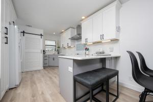 a kitchen with white cabinets and a counter and chairs at Gulf Side Townhomes 20 condo in Gulf Shores
