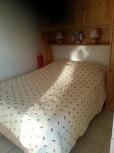 a bed with a white comforter on it at bleu marine in Bormes-les-Mimosas