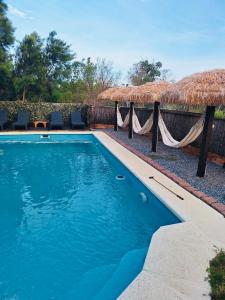 una piscina con una hamaca y un complejo en Altos de Kiyu, en José Ignacio