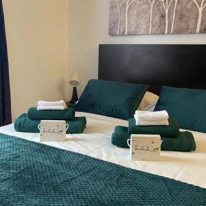 a large bed with green and white pillows on it at Milmari kop in Raška