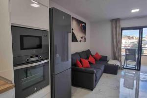 a living room with a couch and a television at Club Paraiso in Adeje