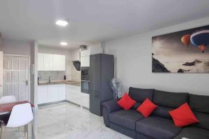 a living room with a couch and a kitchen at Club Paraiso in Adeje