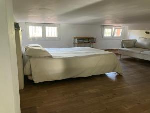 sypialnia z dużym białym łóżkiem i kanapą w obiekcie Beach apartment garden and wifi w mieście Tarifa