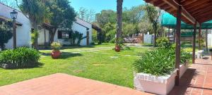 a yard with potted plants and a building at Palmeras apart hotel in Chascomús