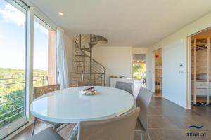 a dining room with a white table and chairs at Villa Nuraghe - By Searly in Costa Dorata +31 photos