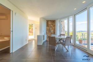 a kitchen and dining room with a table and chairs at Villa Nuraghe - By Searly in Costa Dorata