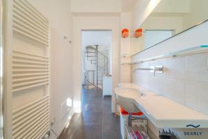 a white bathroom with a sink and a staircase at Villa Nuraghe - By Searly in Costa Dorata