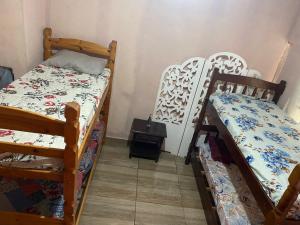a room with two bunk beds and a table at Encontro dos passaros in Sarapuí +5 photos