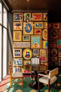 a room with a table and chairs and a wall of pictures at Jungle at 24, City Views and Wonderland Vibes! in Hatillo