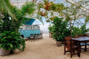 a tent with tables and chairs and a van in the sand at Firefly at 29, City Views and Wonderland Vibes! in Hatillo