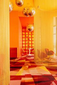 a living room with orange walls and a checkered floor at Firefly at 29, City Views and Wonderland Vibes! in Hatillo