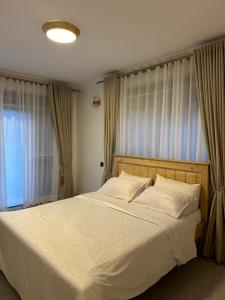 カンパラにあるFlic and Flac apartmentsのベッドルーム(大きな白いベッド、カーテン付)