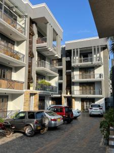 カンパラにあるFlic and Flac apartmentsの建物の前に車が駐車されている駐車場