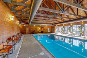 a large swimming pool with chairs and an indoor pool at Whispering Pines in Durango Mountain Resort