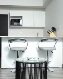 a kitchen with two bar stools and a counter at Teal at 12, City Views and Wonderland Vibes! in Hatillo +34 photos