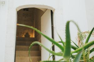 a person sitting on the stairs of a building at Dimora Del Vicolo in Ostuni