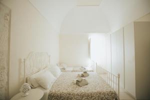 a bedroom with a bed with a teddy bear on it at Dimora Del Vicolo in Ostuni