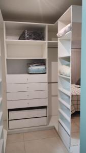 einen begehbaren Kleiderschrank mit weißen Schränken und einem Bett in der Unterkunft Duplex zona calvario in Tandil