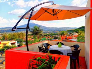 un patio con ombrellone arancione, tavolo e sedie di 4minutos al centro PARA 12, personas 10 en cama y 2en sofa En Promoción a Tequila