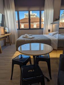 une chambre d'hôtel avec un lit, une table et un lit dans l'établissement Triple A - Psiri Fruit Market Artistic Studios - FREE Parking, à Athènes