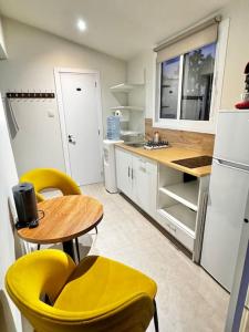 a kitchen with yellow chairs and a table and a refrigerator at Smart Deluxe Studio N9 private Kitchenette Balcony Beach 250m Marina Port 900m in Limassol +4 photos