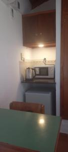 una cocina con encimera y microondas en Palmeras Appart Hotel, en Chascomús