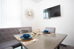 a dining room table with blue dishes and a television at Secrt Sabana 2BR · Bright & Comfortable · Pool & Gym · Parking · Apt 2610 in San José +38 photos