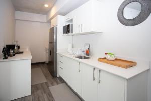 a white kitchen with a sink and a refrigerator at Secrt Sabana 2BR · Bright & Comfortable · Pool & Gym · Parking · Apt 2610 in San José