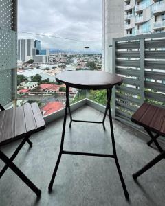 a table and two benches on a balcony with a view at Serenity at 12, City Views and Wonderland Vibes! in Hatillo