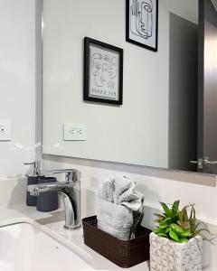 a bathroom with a sink with a mirror and towels at Serenity at 12, City Views and Wonderland Vibes! in Hatillo