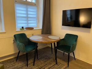 a table and two green chairs in a room at Apartment 6 Große Brüdergasse in Bautzen