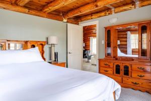 1 dormitorio con cama blanca y tocador de madera en Forest Hideaway, en Hespeler 34 fotos más