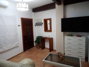 a living room with a flat screen tv on the wall at El callejón del Santo in Ubrique