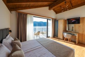 a bedroom with a bed with a view of the ocean at Lavalliere Hotel & Villas in Sarnitsa