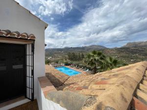 een villa met zwembad en bergen op de achtergrond bij Hacienda Riogordo in Ríogordo