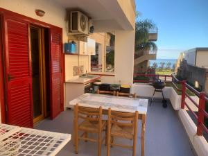 ミラッツォにあるCasa Mare Milazzo - Lenzuola e Asciugamani non inclusi nel prezzoのバルコニーにテーブルと椅子が置かれたパティオ