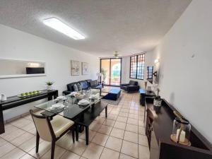 a living room with a dining table and a kitchen at Crescent Beach Apt Ocean View in Humacao