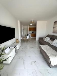 Una sala de estar con un sofá y un televisor de pantalla plana. en Ático Mirador del Atlántico, en Chayofa