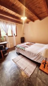 ein Schlafzimmer mit einem Bett und einem Tisch und einem Fenster in der Unterkunft Shelter Patagonia Hostal in El Bolsón