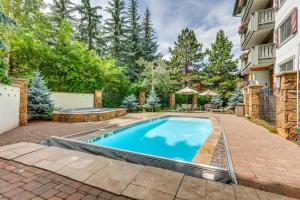 a swimming pool in a yard next to a building at 9 Vail Road Vail Village 2 to 4 Bedrooms by Vail Realty in Vail